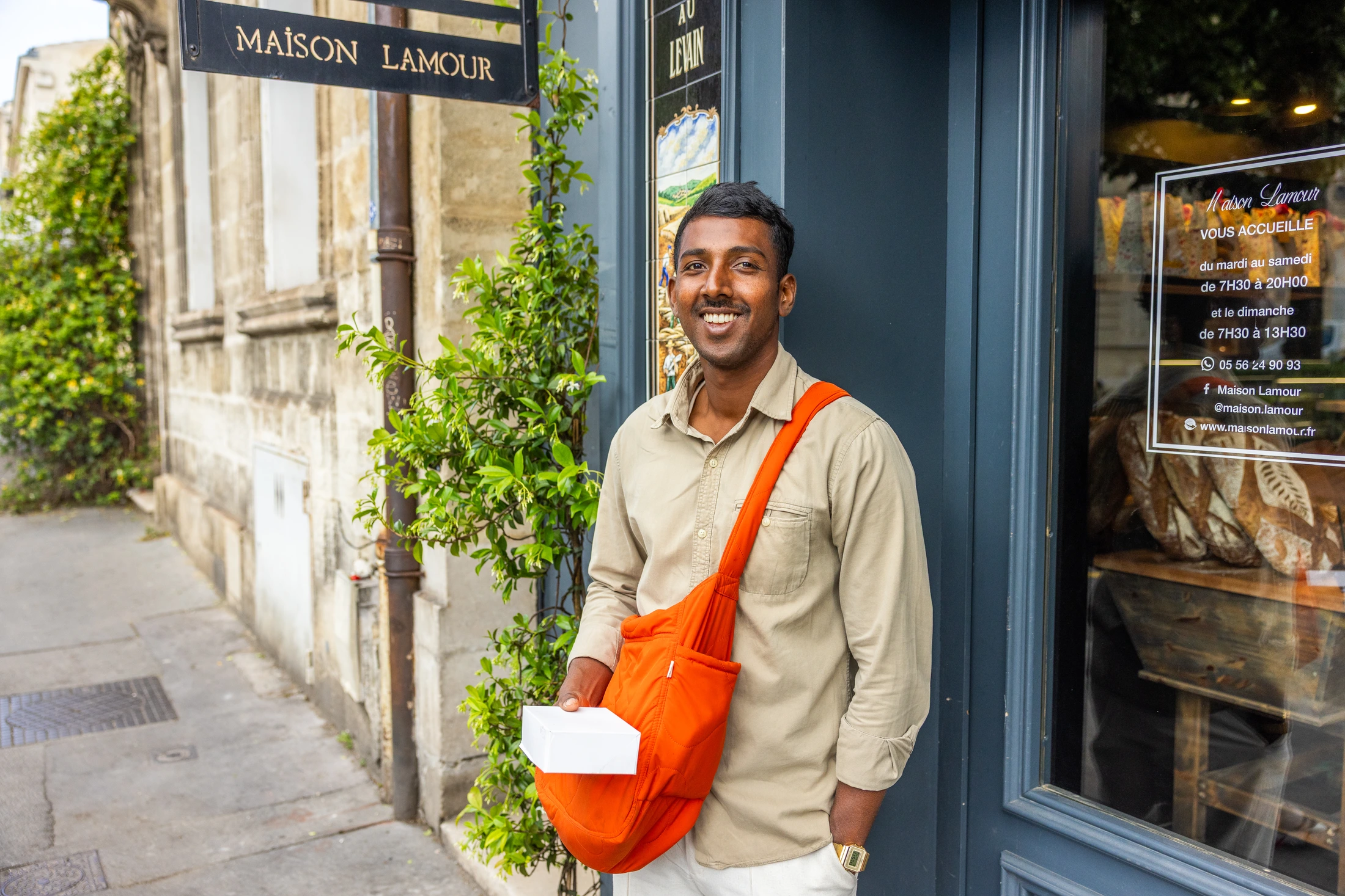 Livreur souriant devant la boulangerie Maison Lamour à Bordeaux, photographié par Kandra Photo
